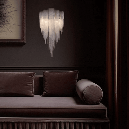 Decorative wall light fixture above a brown sofa with cushions.