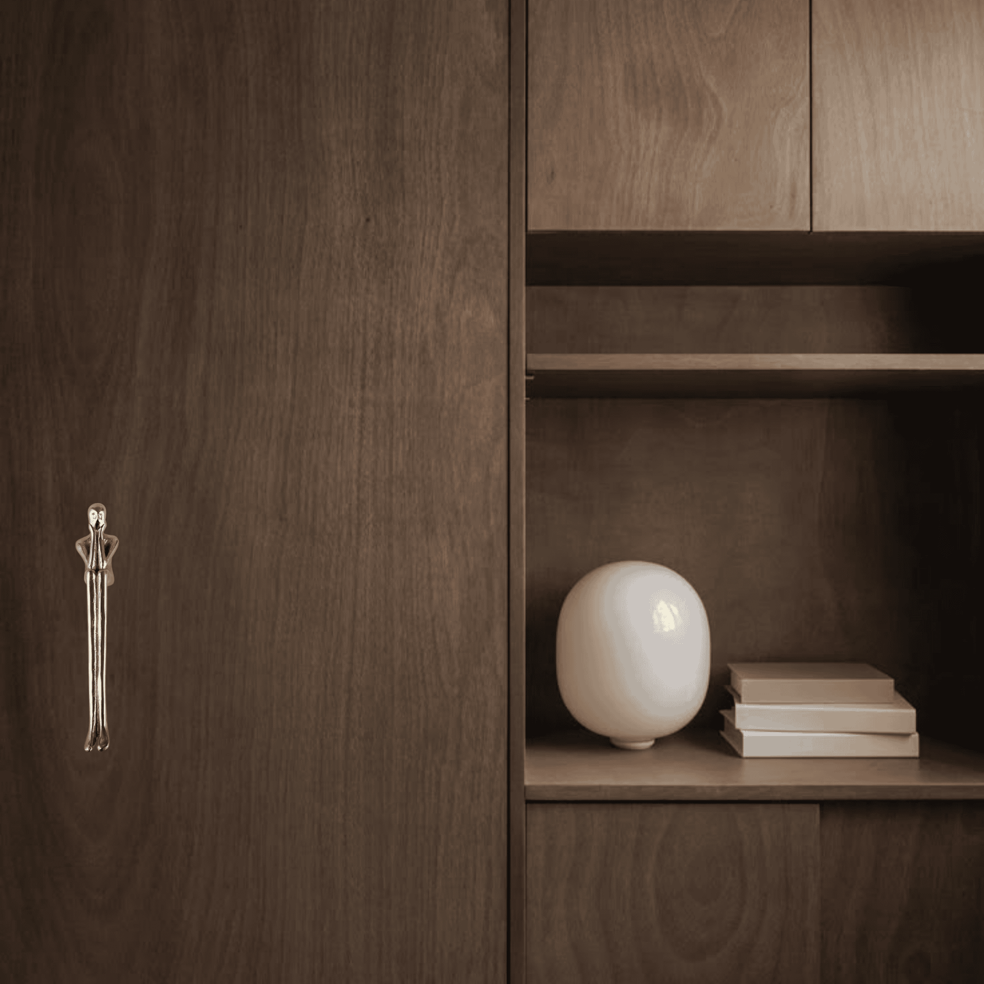 Wooden cabinet with a decorative handle and a white spherical object on a shelf.