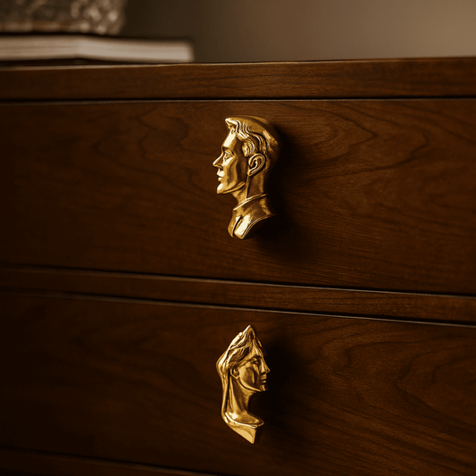 Wooden drawer with gold face-shaped handles on a dark background