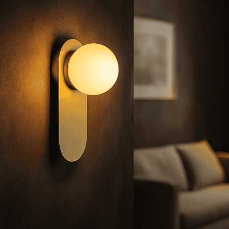 Wall-mounted light fixture in a dimly lit room with a sofa in the background