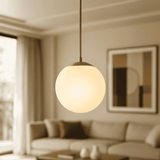 Modern pendant light hanging in a living room with a blurred background
