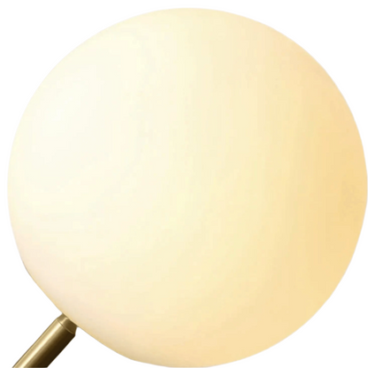 Round light fixture with a gold base on a beige background