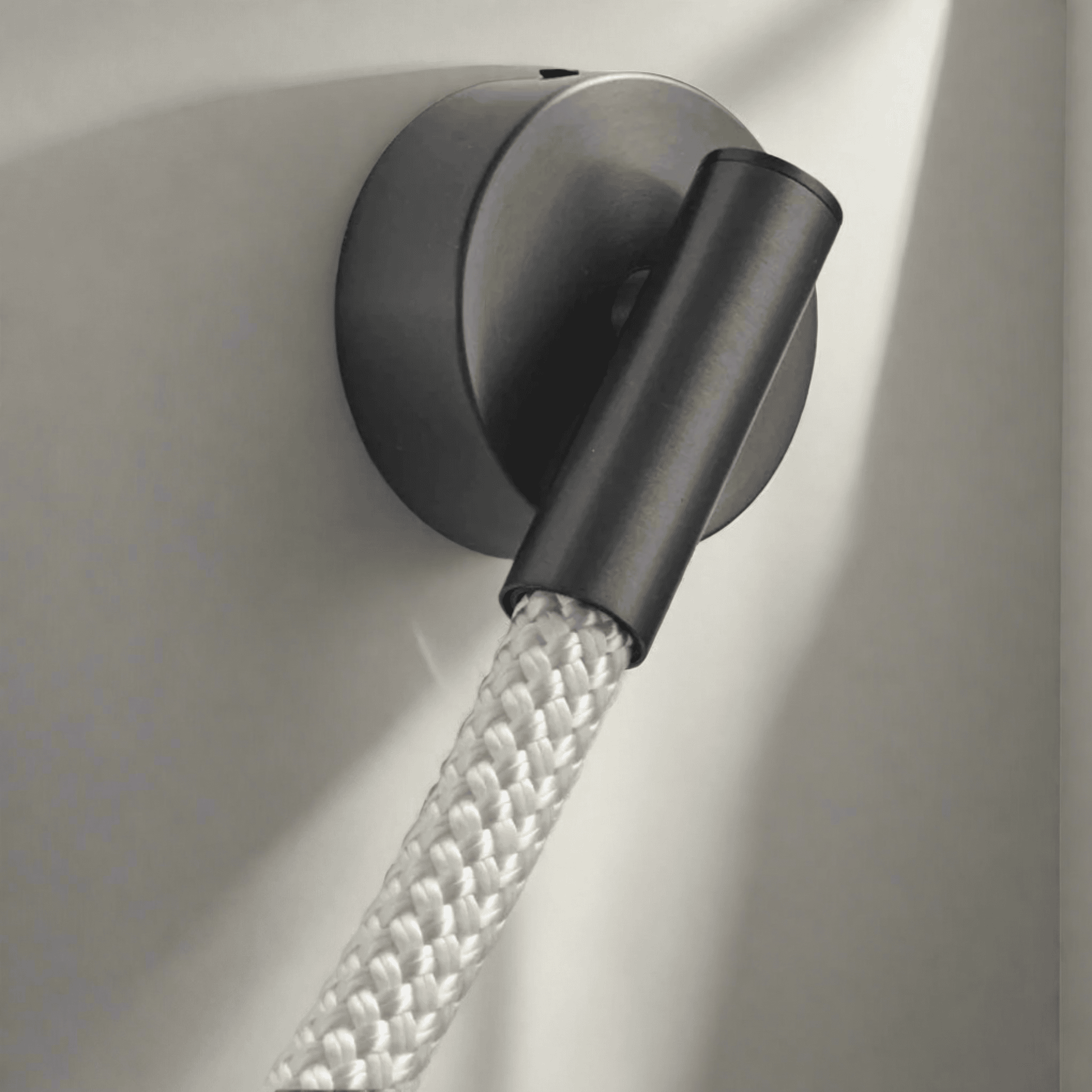 Black wall light fixture with a flexible hose on a neutral background