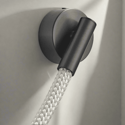 Black wall light fixture with a flexible hose on a neutral background