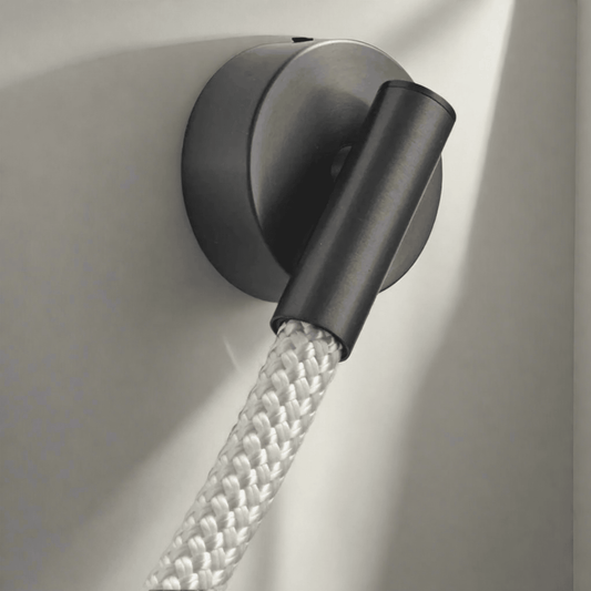 Black wall light fixture with a flexible hose on a neutral background