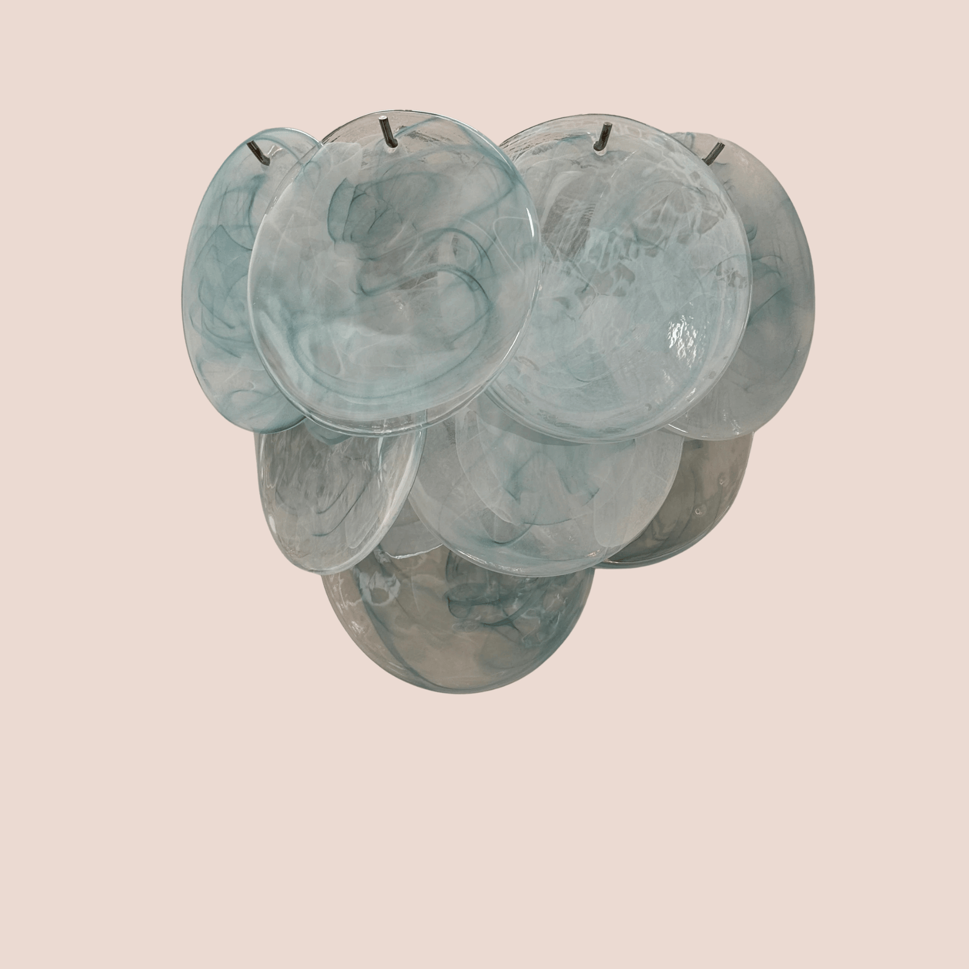 Set of six teal glass bowls stacked on a beige background