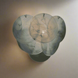Decorative wall sconce with a marble-like finish on a textured beige background