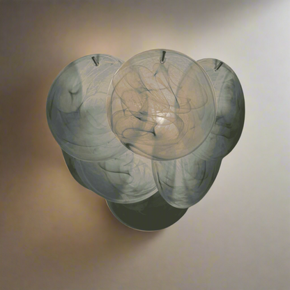 Decorative wall sconce with a marble-like finish on a textured beige background
