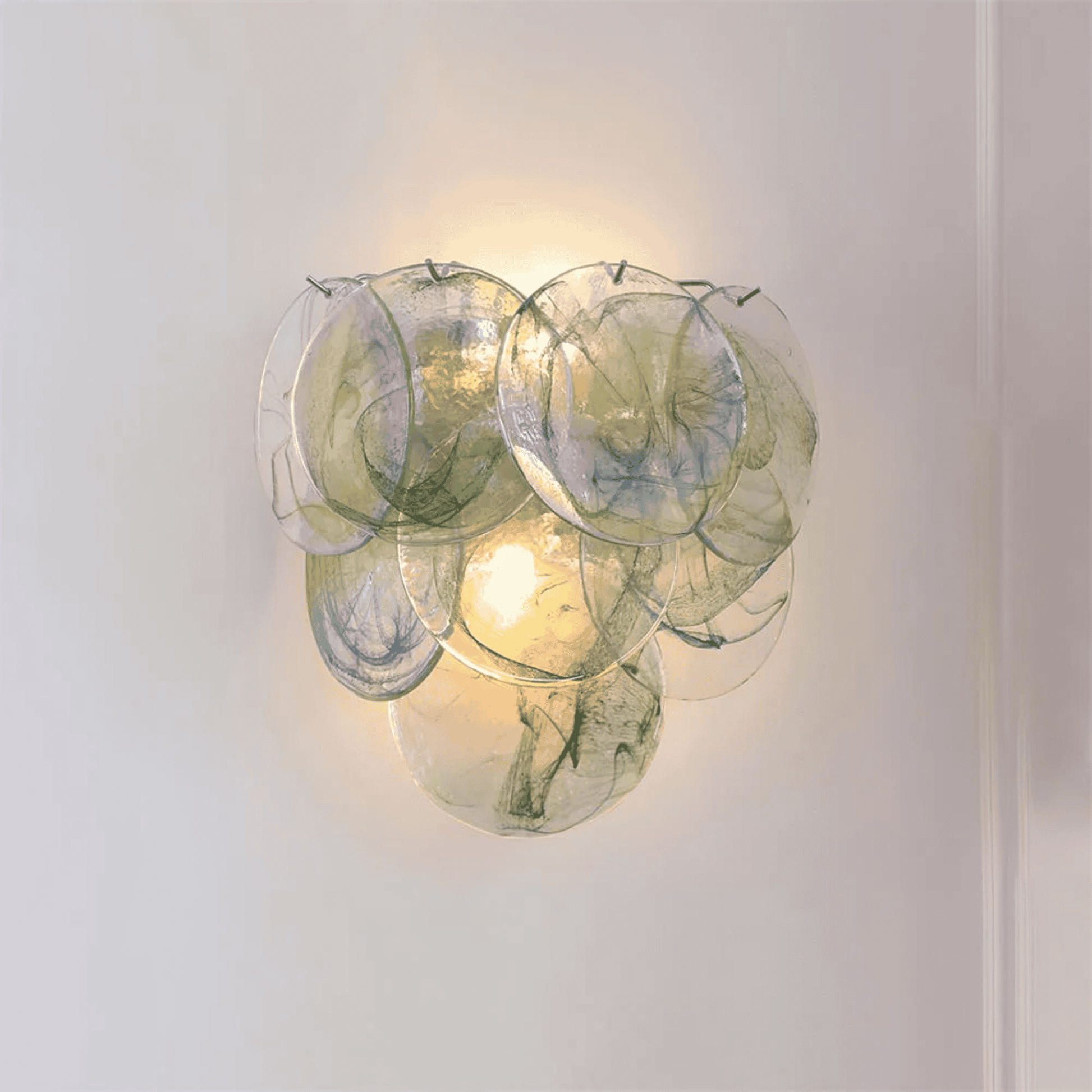 Decorative wall light fixture with glass panels on a plain background
