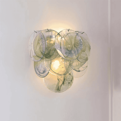 Decorative wall light fixture with glass panels on a plain background