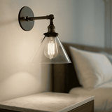 Retro Glass Wall Sconce with cone shade used as a bedside lamp. Warm LED lighting enhances cozy bedroom ambiance.