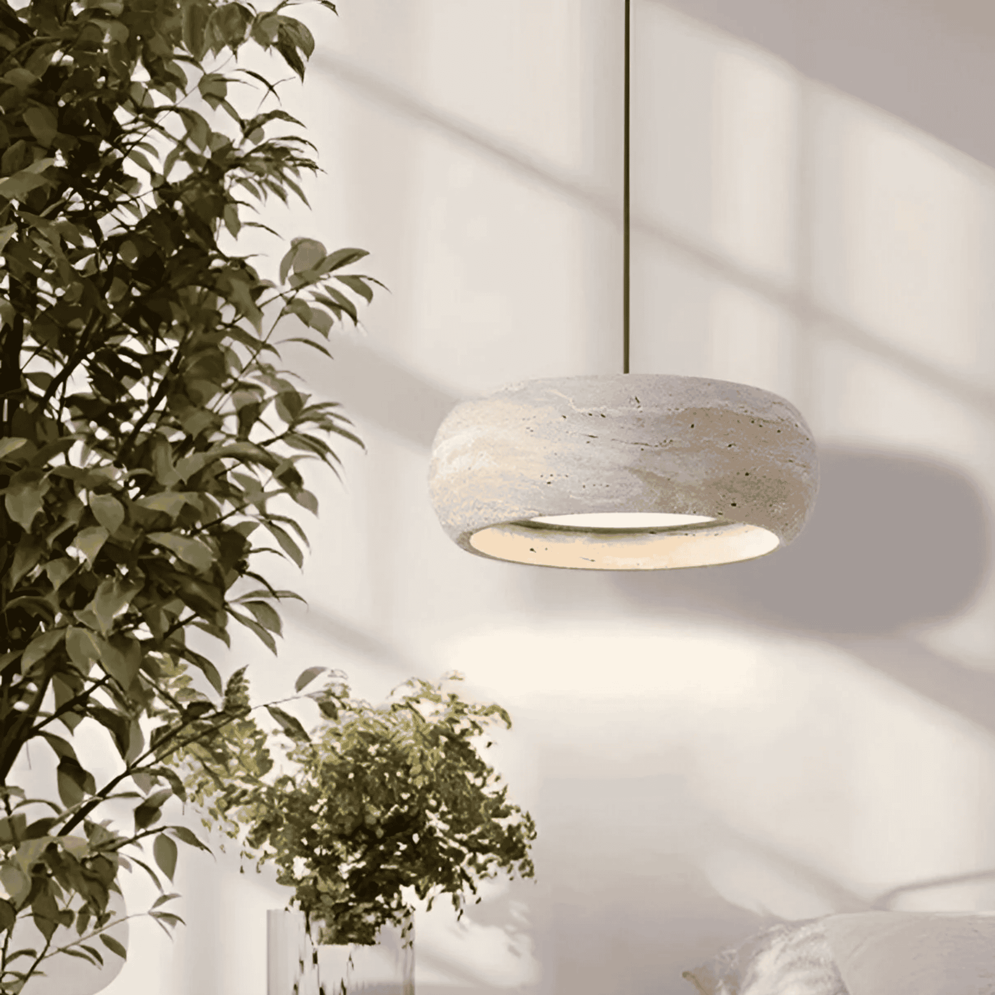 Ithaca travertine LED pendant lamp suspended in a bright bedroom setting, offering dimmable lighting for cozy and elegant ambiance.