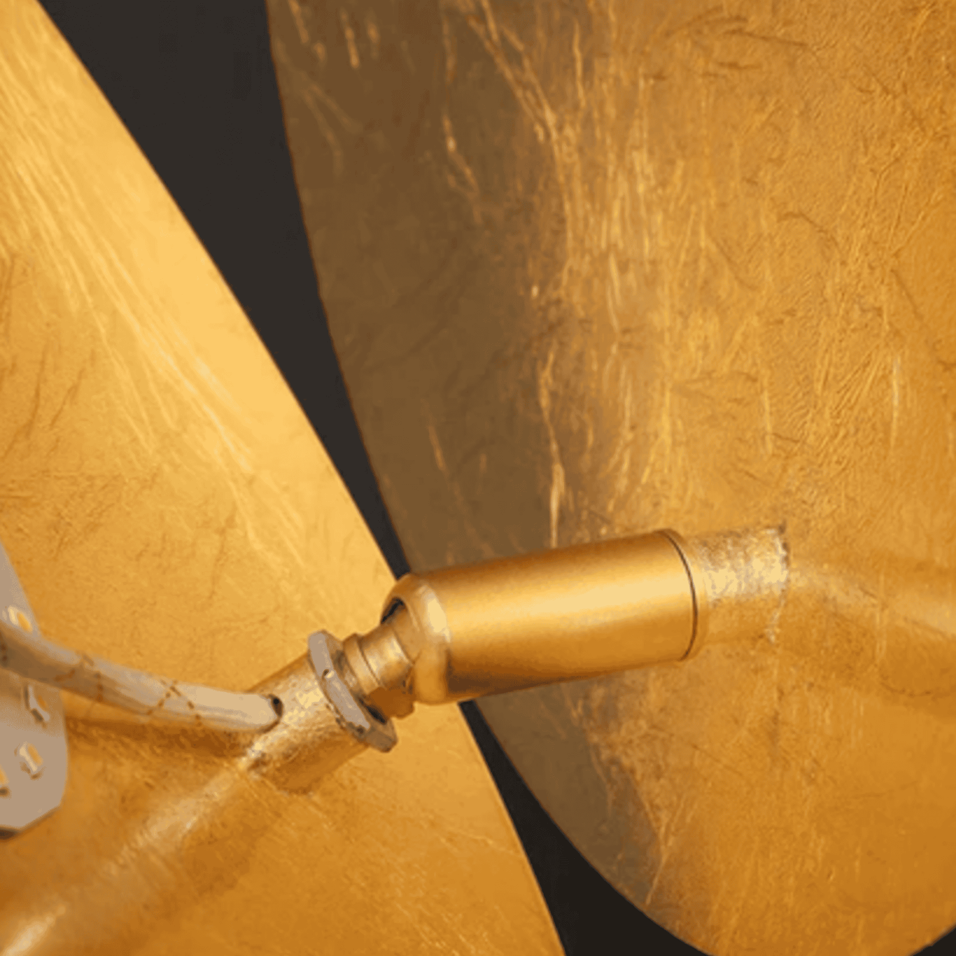 Detailed view of gold copper hinge in Moon Eclipse LED Wall Light. Durable bronze alloy construction enhances modern lighting design.