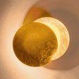 Fully illuminated Moon Eclipse LED Wall Light with golden glow. Stylish round design for modern home lighting and decor.