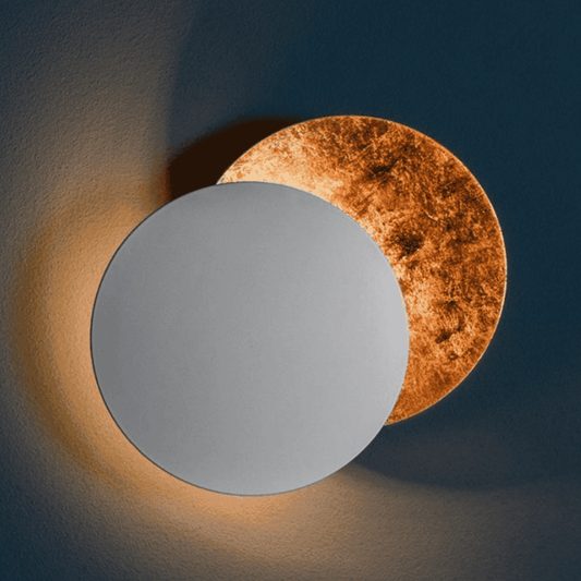 Silver and bronze Moon Eclipse LED Wall Light mounted on wall. Creative lighting fixture for hallways, bedrooms, or living rooms.