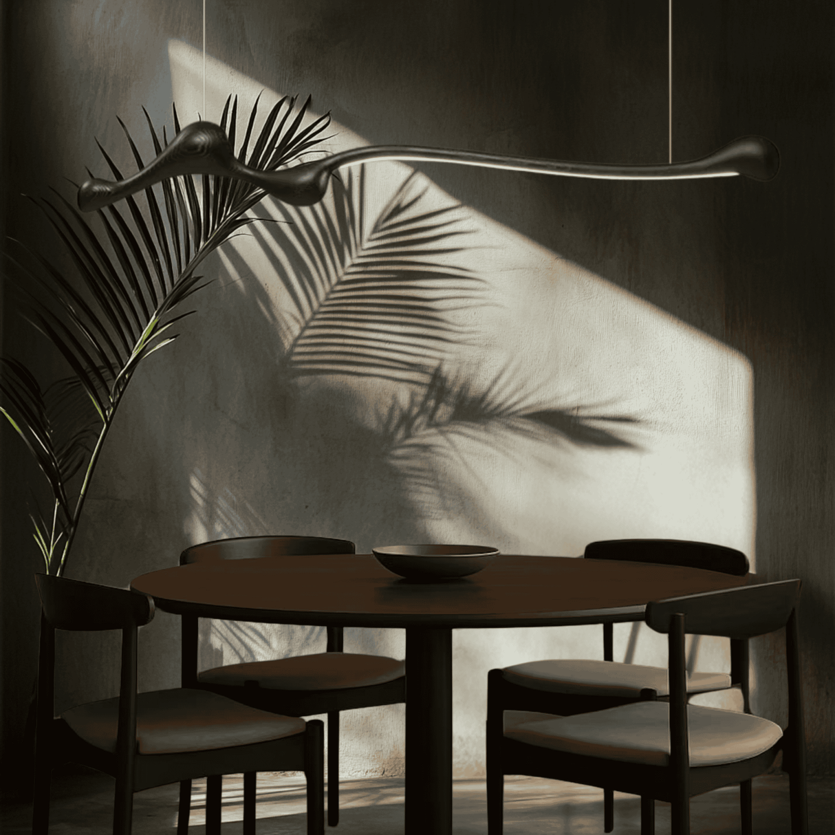 Black ZenRay Ashwood Pendant Light in a moody dining room, casting dramatic shadows with dimmable LED illumination.