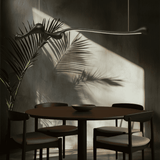 Black ZenRay Ashwood Pendant Light in a moody dining room, casting dramatic shadows with dimmable LED illumination.