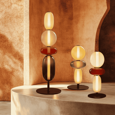 Modern table lamps with glass shades on a decorative platform against a warm-toned wall.

