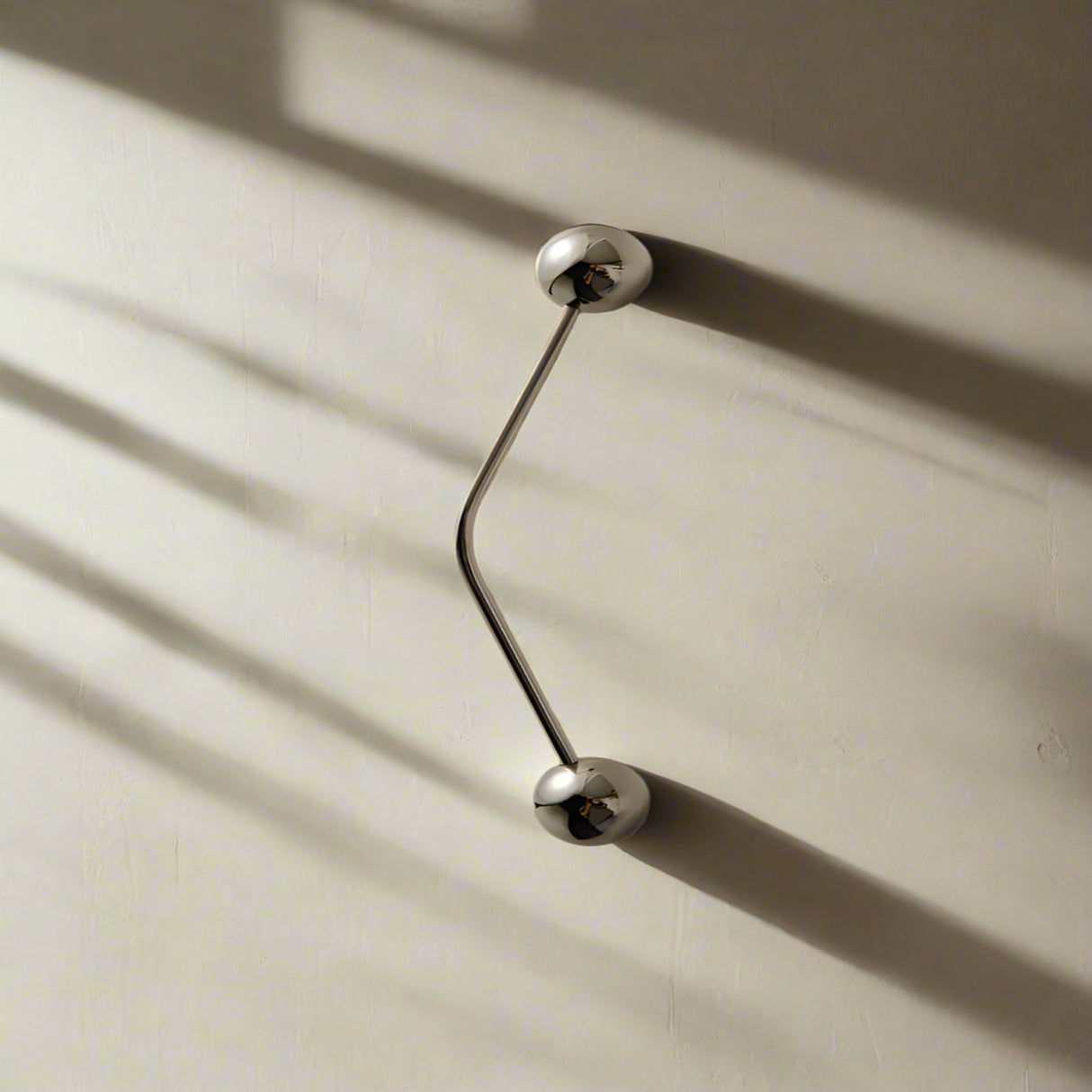 Silver door handles on a beige wall