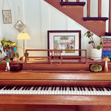 Wooden piano with decorative items on a staircase