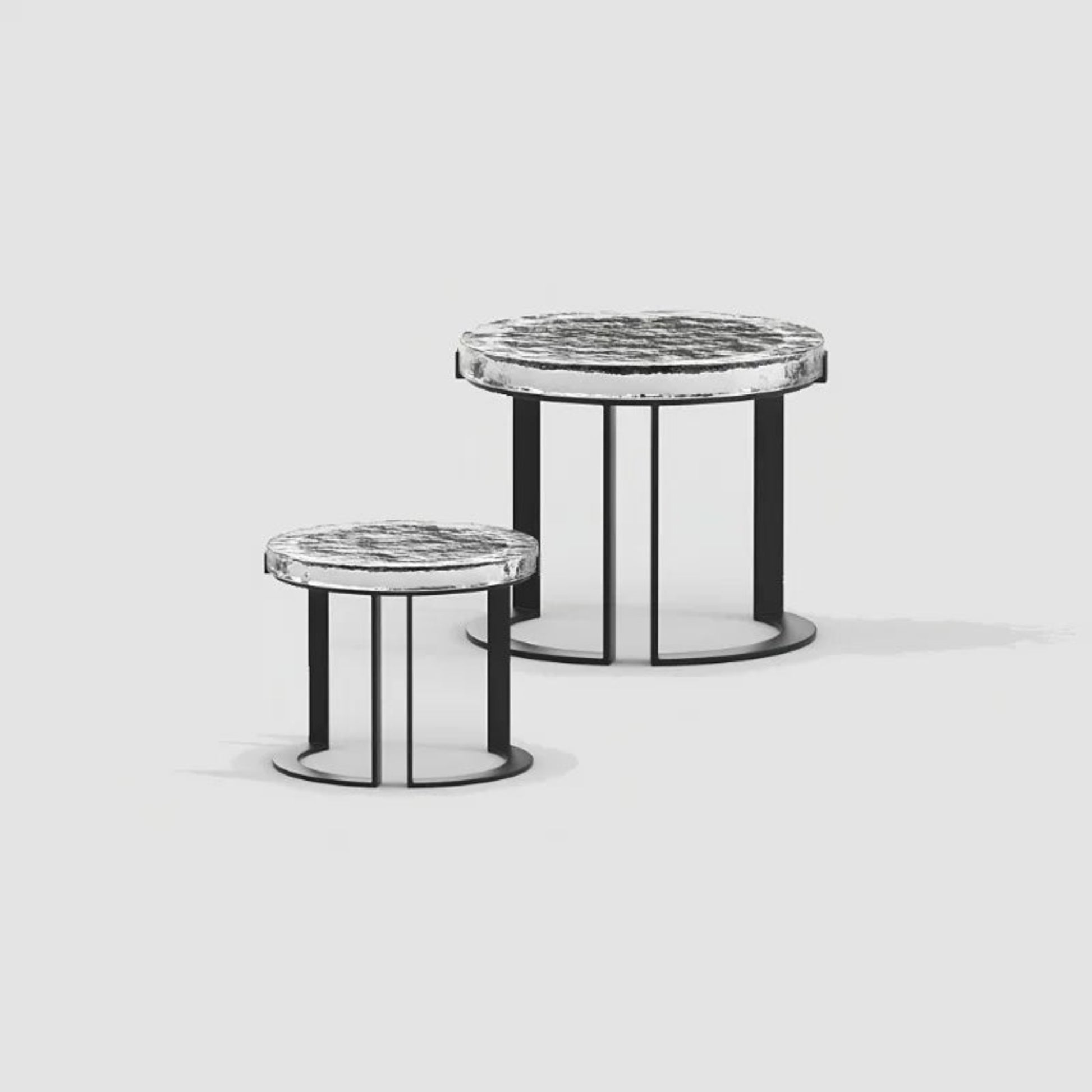 Two round side tables with marble tops and black metal bases on a light gray background