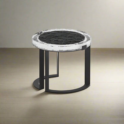 Small round table with marble top and black metal frame on a light gray background