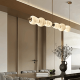 Modern pendant light fixture hanging above a dining table in a stylish interior setting.