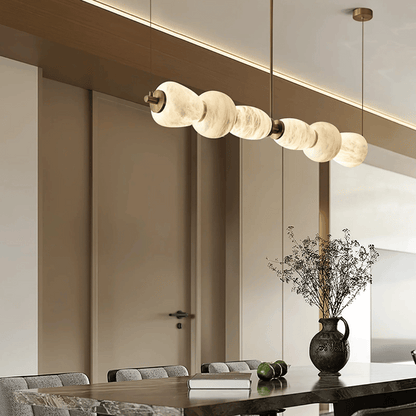 Modern pendant light fixture hanging above a dining table in a stylish interior setting.