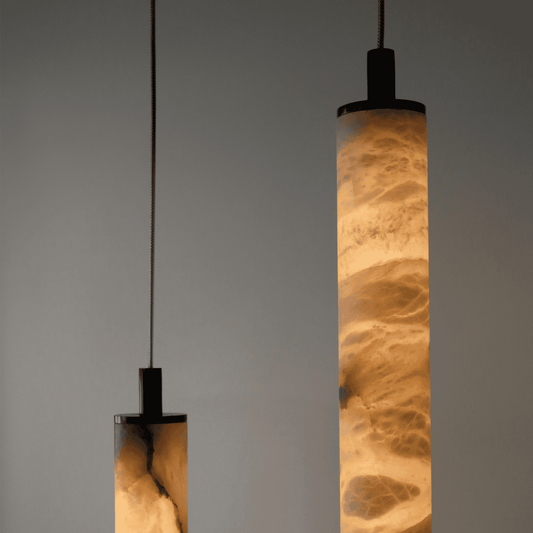 Two pendant lights with textured glass shades on a gray background