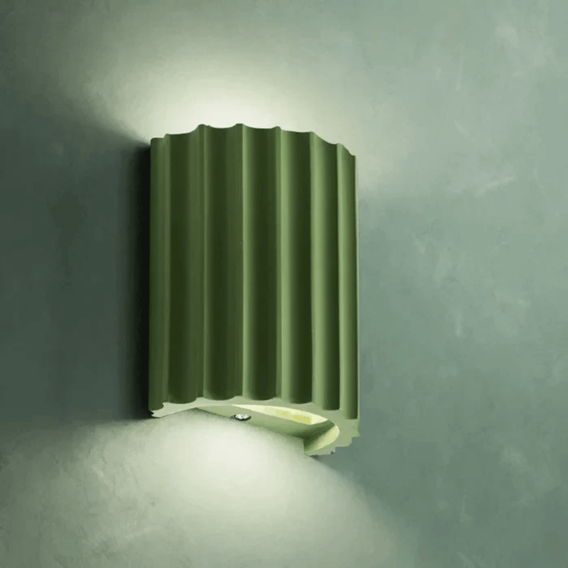 Green wall-mounted light fixture on a gray wall
