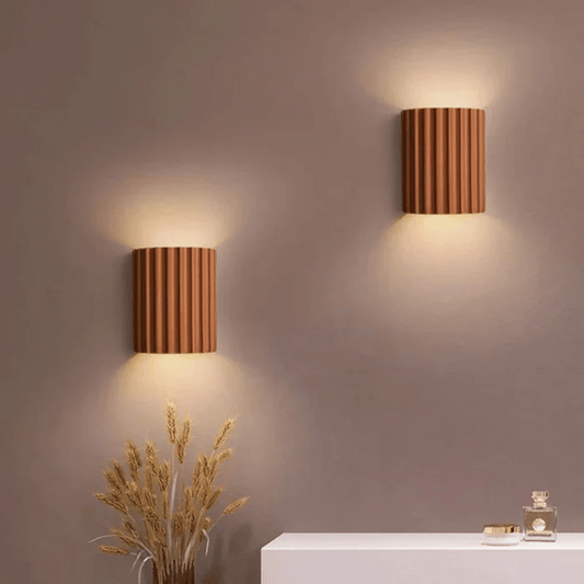 Two wooden wall lights on a neutral wall with decorative elements below.