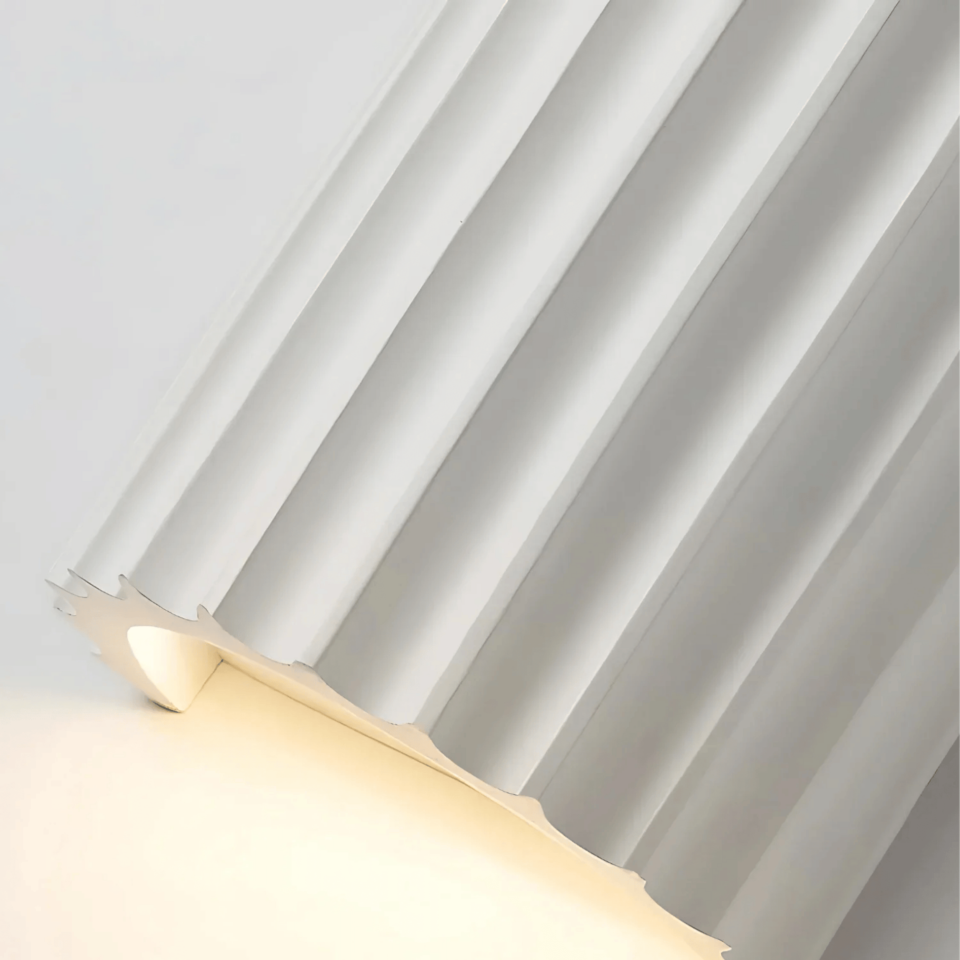 Modern wall light fixture with a metallic finish on a neutral background