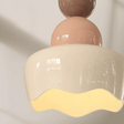 Ceiling light fixture with pink and beige design on a plain background