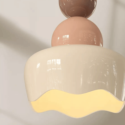 Ceiling light fixture with pink and beige design on a plain background