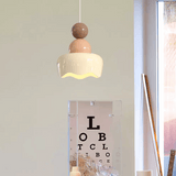 Modern pendant light hanging above a mirror with an eye chart, in a room setting.