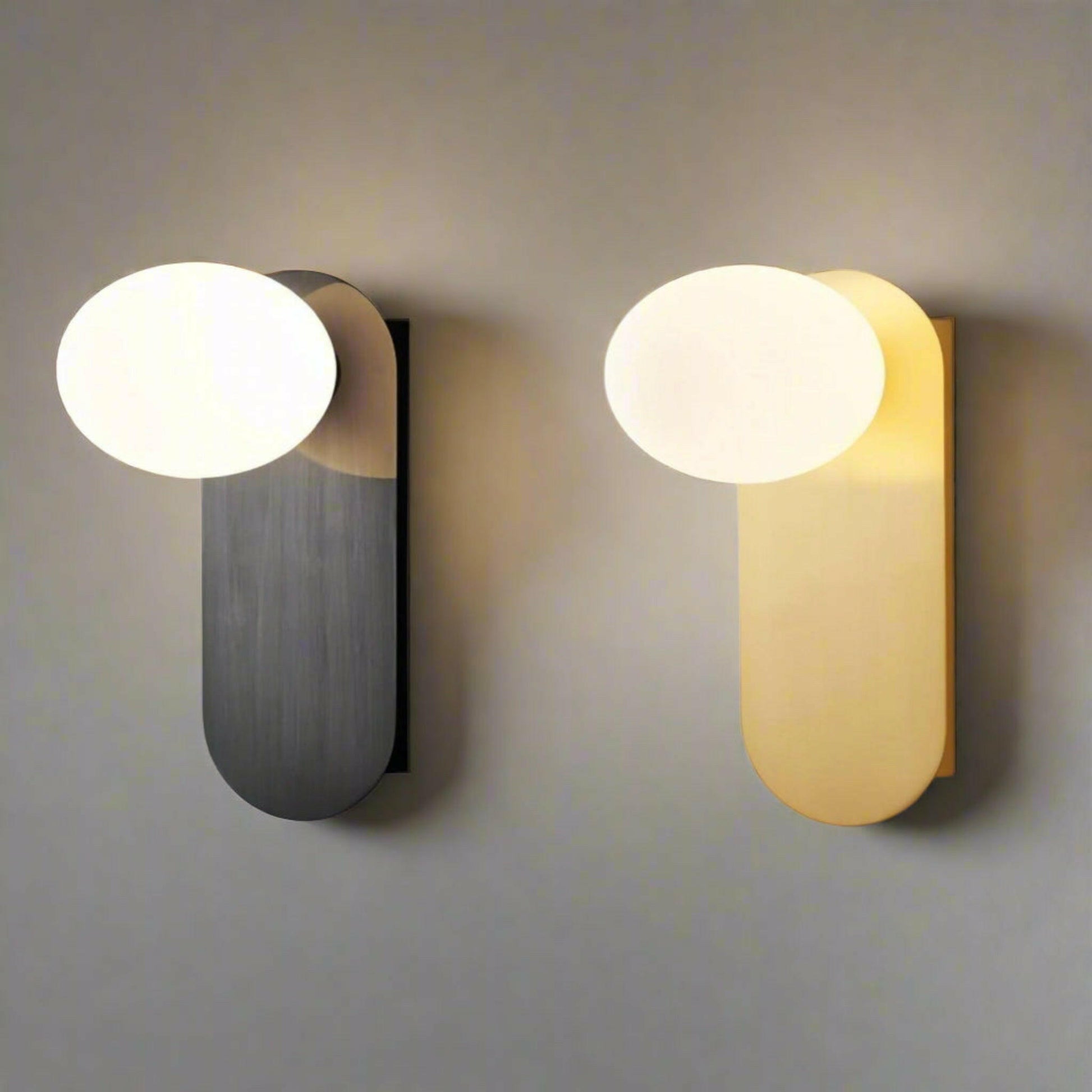 Two wall lights, one black and one gold, on a plain background