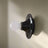 Black wall light fixture with a white bulb on a light gray background