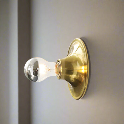Gold wall light fixture on a white wall with 'Gold' label above.
