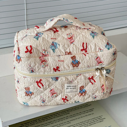 Patterned travel bag with teddy bears and bows on a white surface.