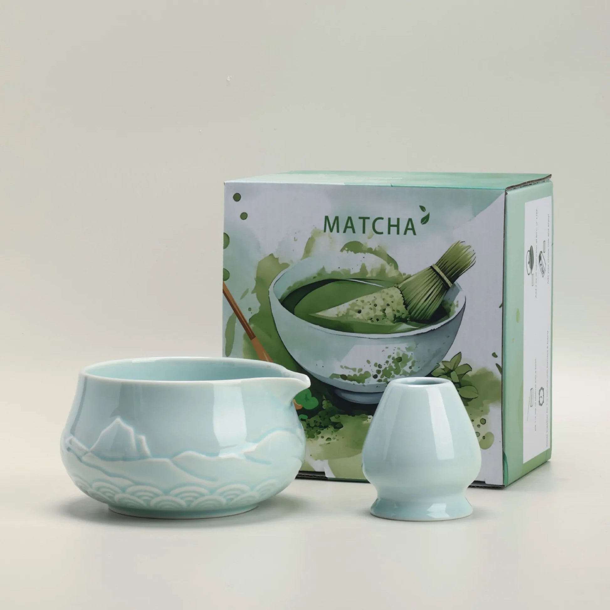 Teal ceramic matcha set with a box labeled 'Matcha' on a light gray background