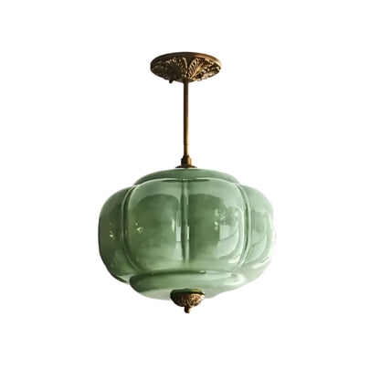 Green glass pendant light fixture on a white ceiling