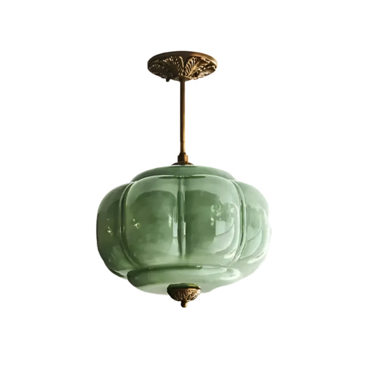 Green glass pendant light fixture on a white ceiling