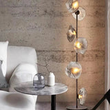 Modern interior with a floor lamp, table, and sofa against a textured wall.