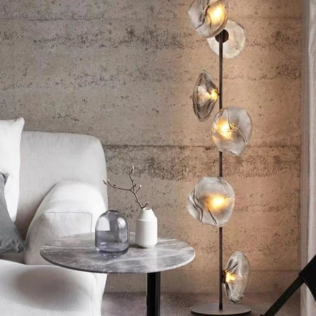 Modern interior with a floor lamp, table, and sofa against a textured wall.