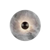 Round wall light fixture with a textured surface on a gray background