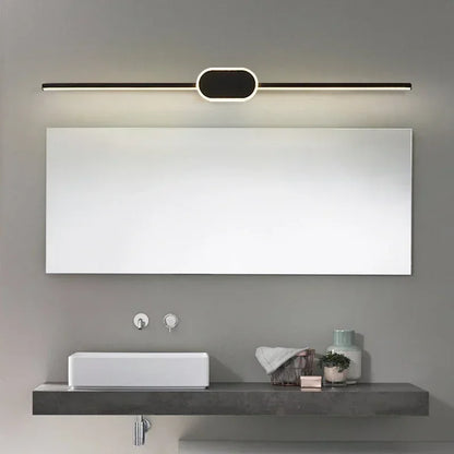 Modern bathroom setup with a large mirror, light fixture, sink, and decorative items.
