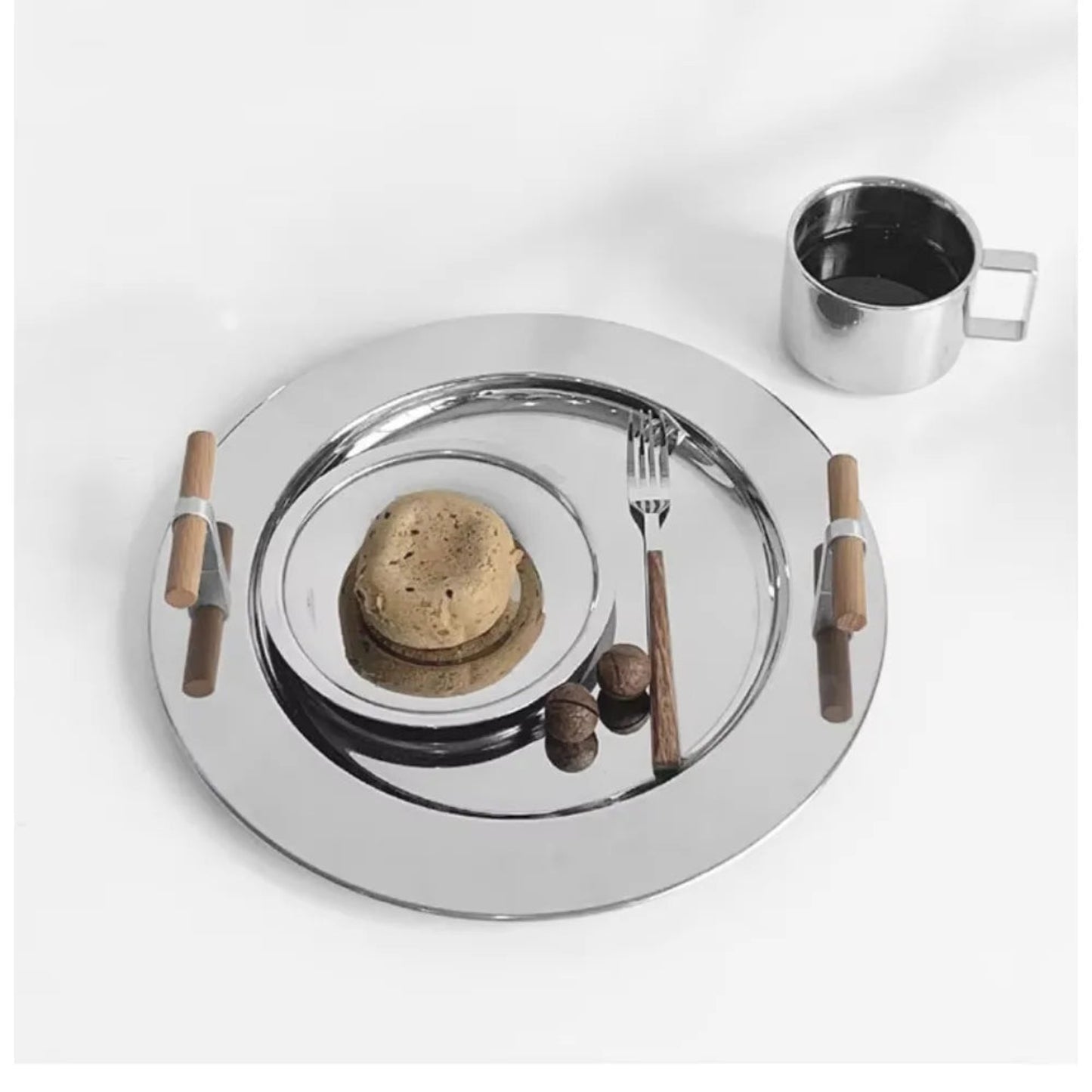Round metallic tray with wooden items on a white background