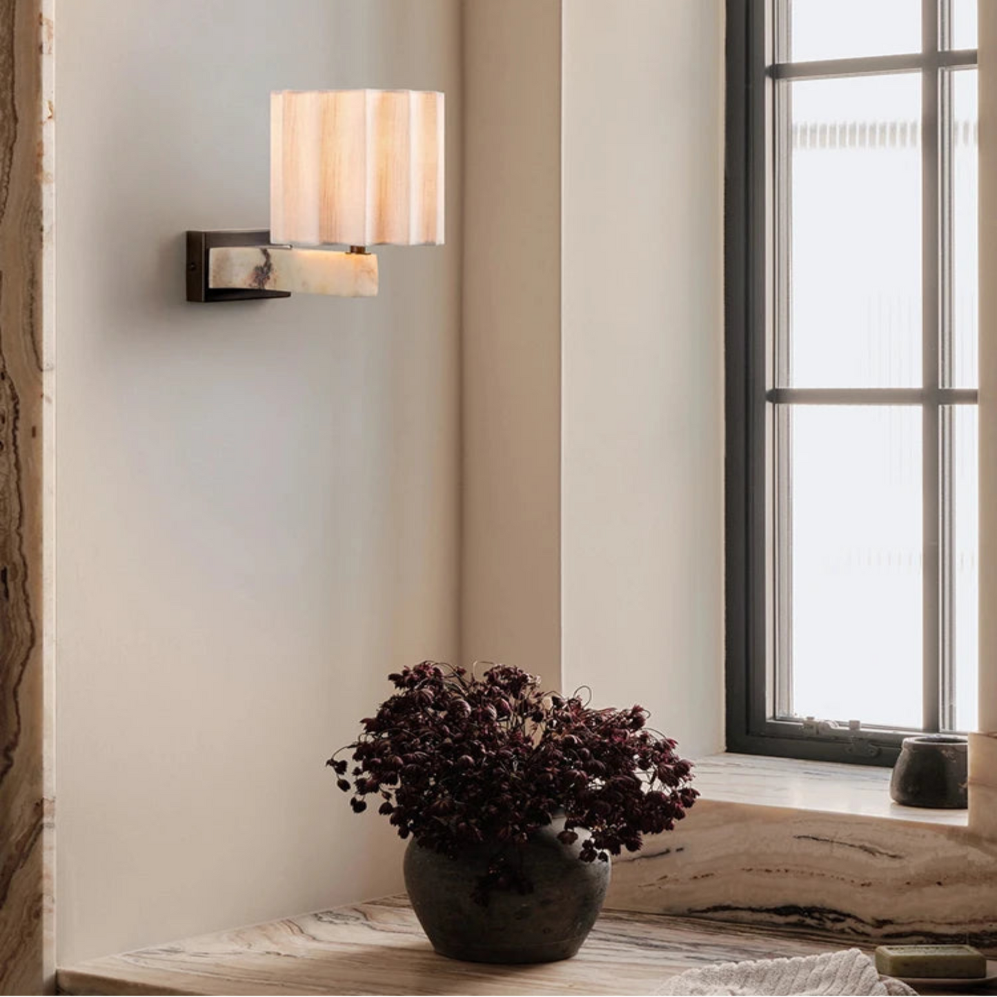 Wall-mounted light fixture on a wall with a window in the background