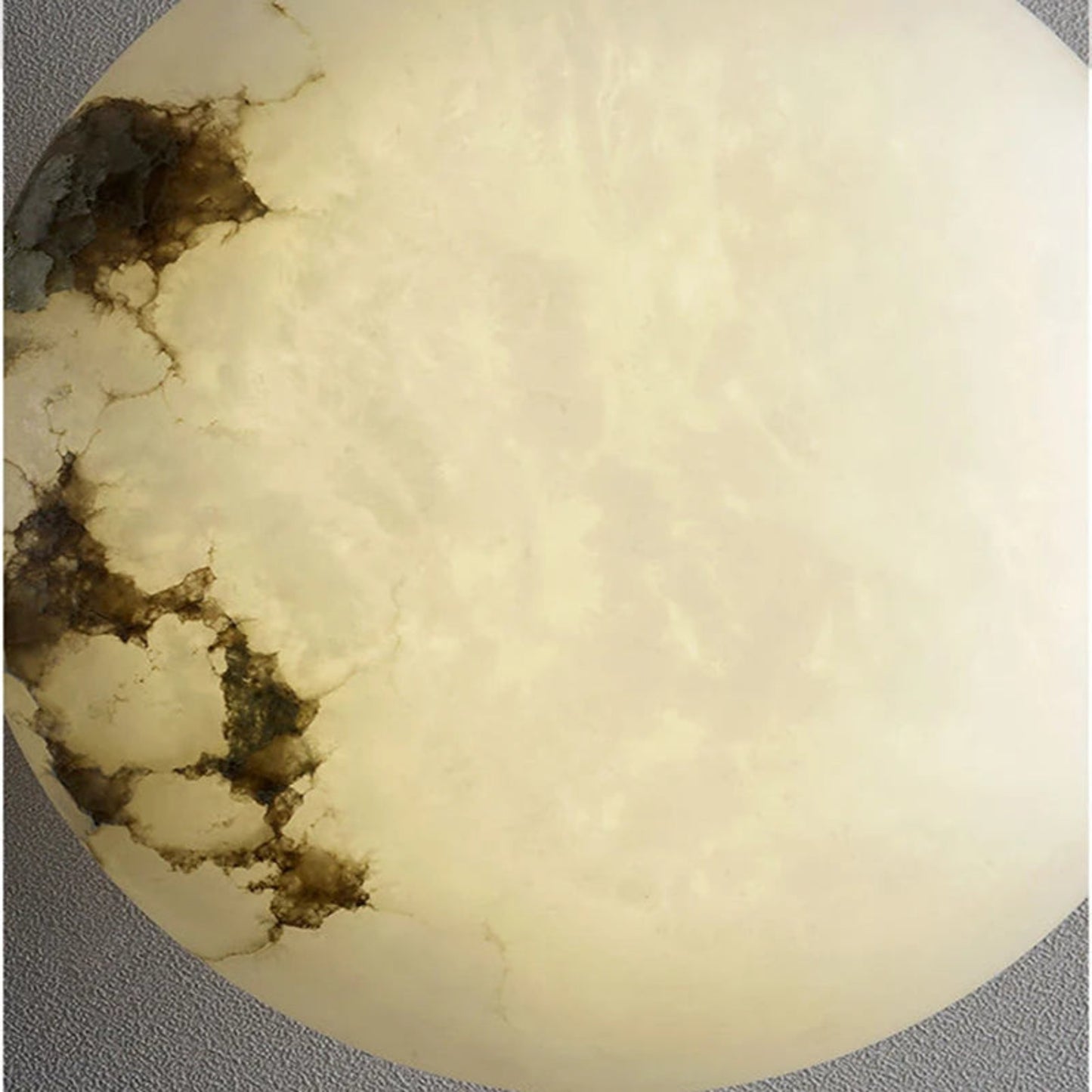 Close-up of a textured beige stone with brown patches on a gray background