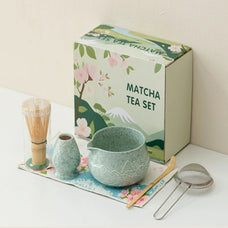 Matcha tea set with a green box featuring matcha-themed illustrations on a white surface.